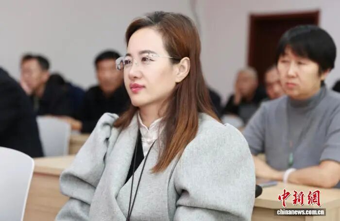 图为外出学习中认真听讲的康枝英